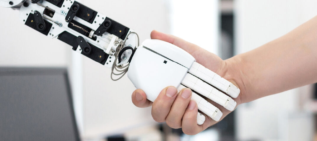 Bild von einer Hand die eine Roboter-Hand greift