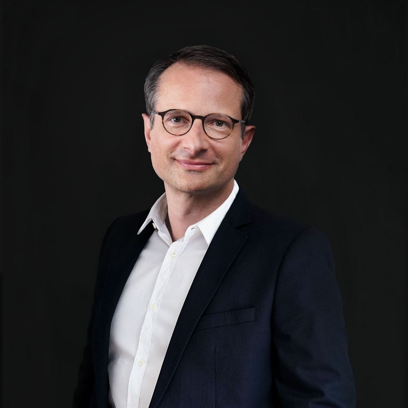 Bruno Machiels, Aufsichtsrat Portraetfoto von Bruno Machiels vor grauem Hintergrund