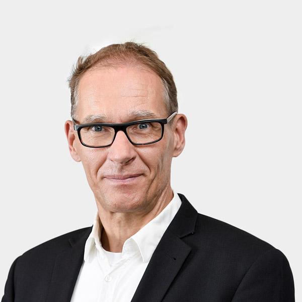 Marc Emde, Senior Expert Portraetfoto von Marc Emde vor grauem Hintergrund