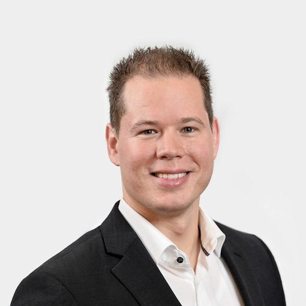 Marcel Sambale, Consultant Portraetfoto von Marcel Sambale vor grauem Hintergrund