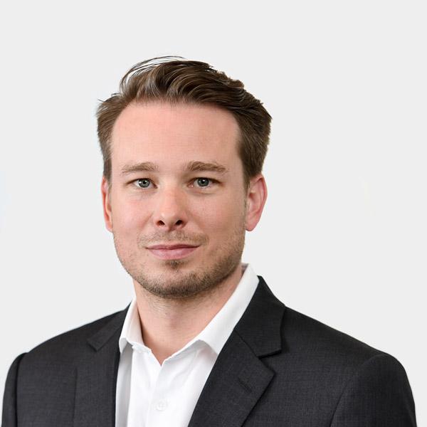 Jonas Van Thiel, Principal Portraetfoto von Jonas Van Thiel vor grauem Hintergrund