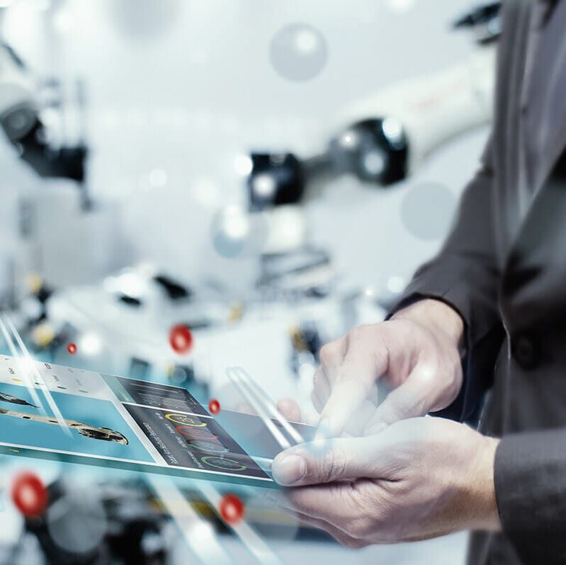 End-to-End Digitalisierung Mann mit futuristischem Tablet in einer Fabrik mit End-to-End Digitalisierung