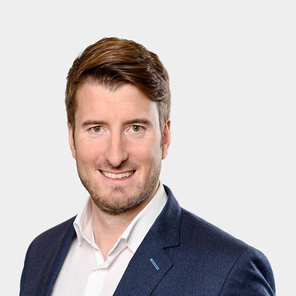 Martin Groicher, Senior Consultant Portraetfoto von Martin Groicher vor grauem Hintergrund