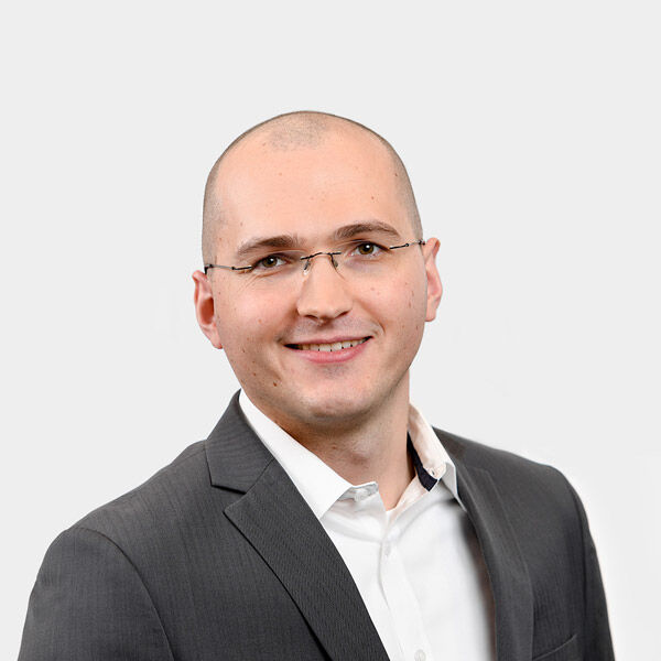 Sebastian Grundstein, Senior Consultant Portraetfoto von Sebastian Grundstein vor grauem Hintergrund
