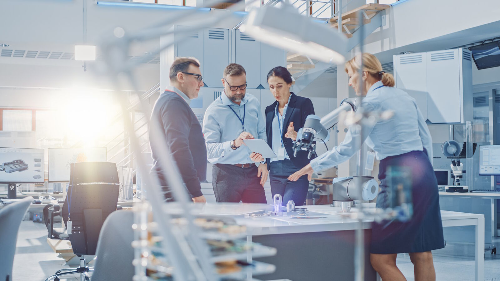 Employees in R&D discussing at a work table.