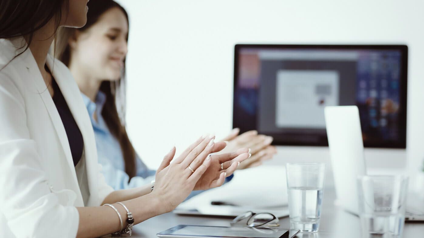 ROI Case Study -Lean Digital Manager Zwei sitzende Frauen klatschen