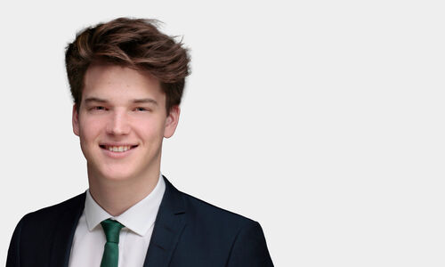 Portraitfoto von Moritz Waubke vor grauem Hintergrund