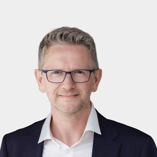 Portraetfoto von Björn Sixt vor grauem Hintergrund