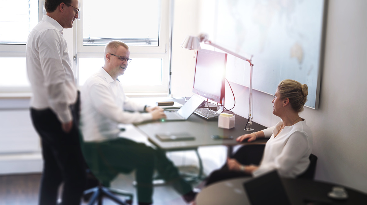 A casual conversation among three employees in an office.