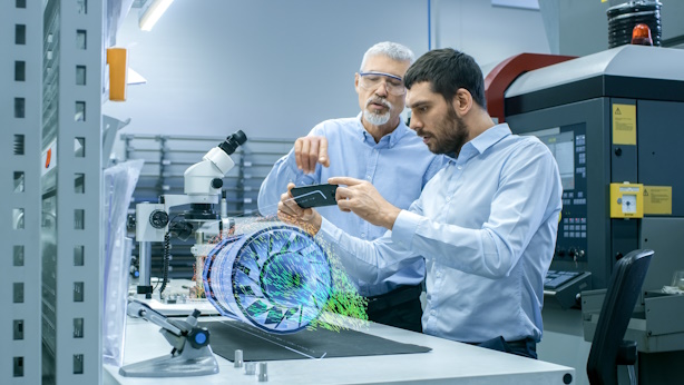 Two engineers work on a turbine using AR technology.