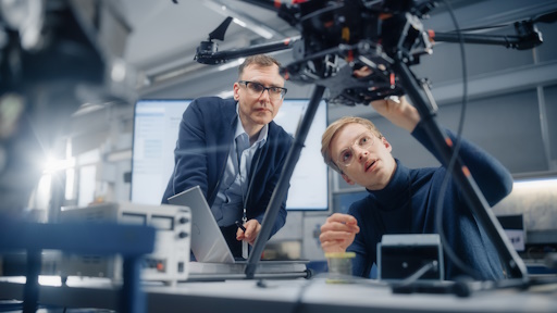 Two engineers work on a drone in a development department